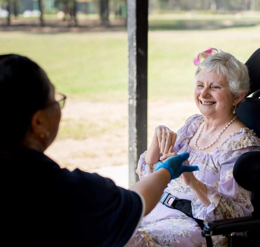 Support worker with a woman using a wheelchair outdoors